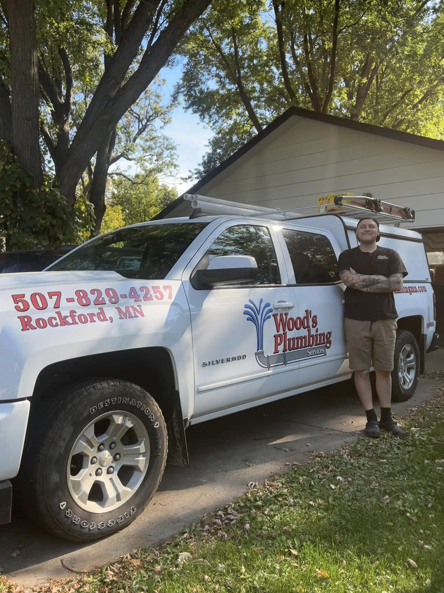 Gage Wood owner of Woods Plumbing Services standing next to his service truck
