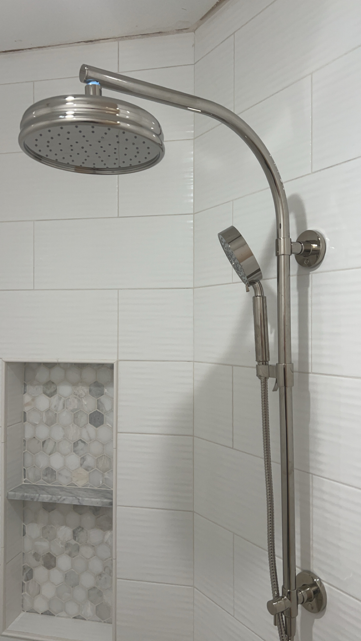 White subway tile shower with new chrome shower head installed